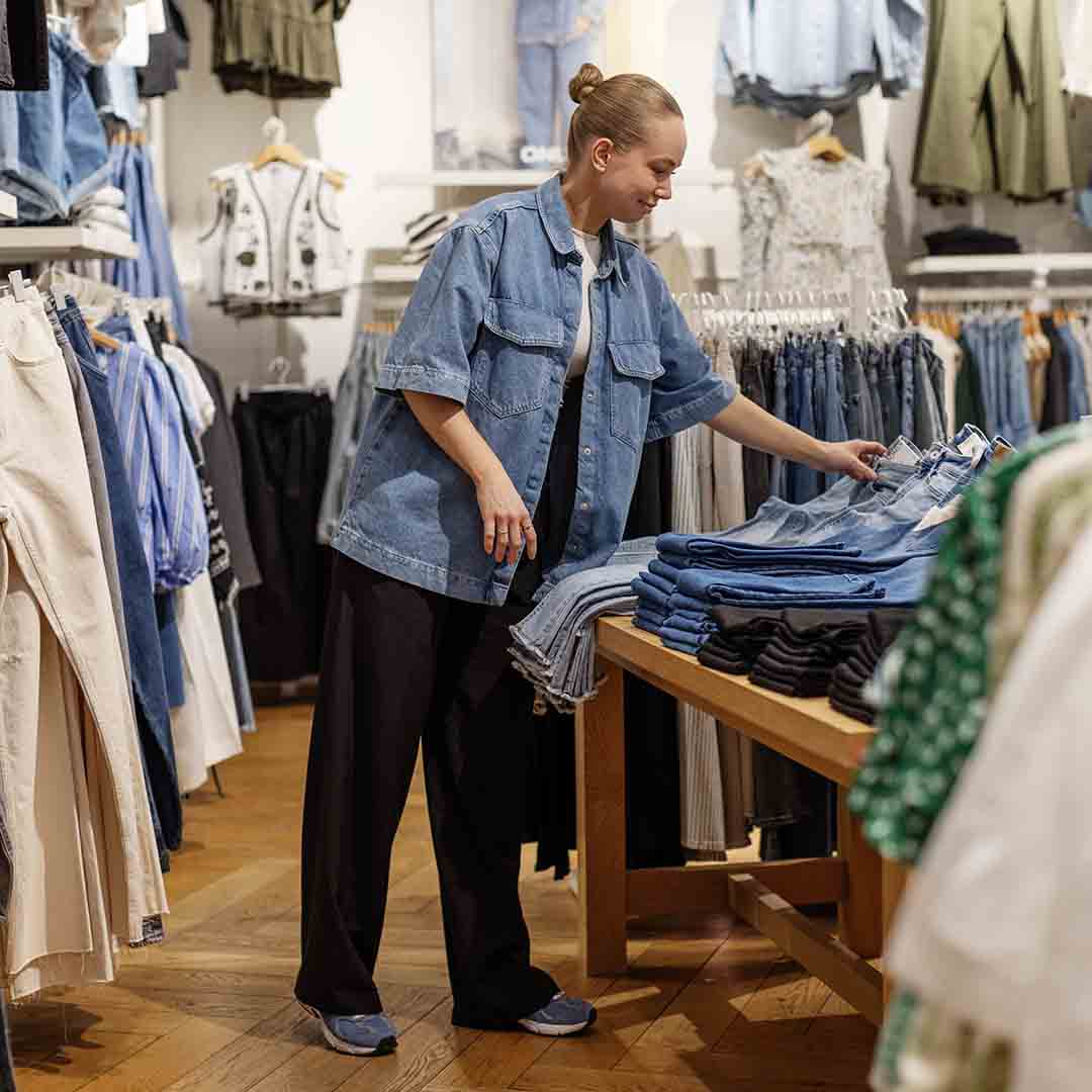 Employee from Only in Frederiksberg placing jeans on the shelf.